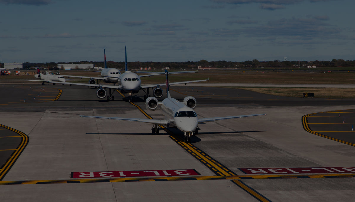 FAA airport taxiway markings, including yellow centerline and red runway holding position markings, as airliners taxi.